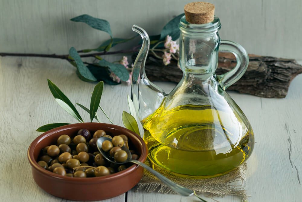 Olive,Oil,And,Arbequina,Olives,On,Birch,Wood