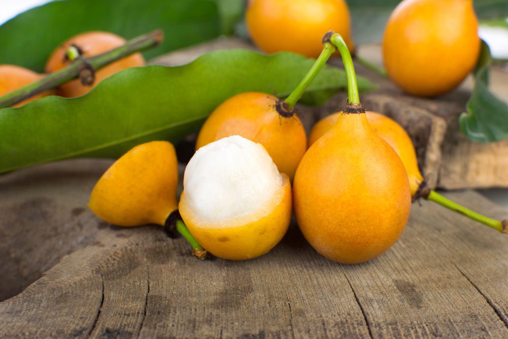Open,Bolivian,Exotic,Fruit,Called,Achachairu,In,Wood,Background